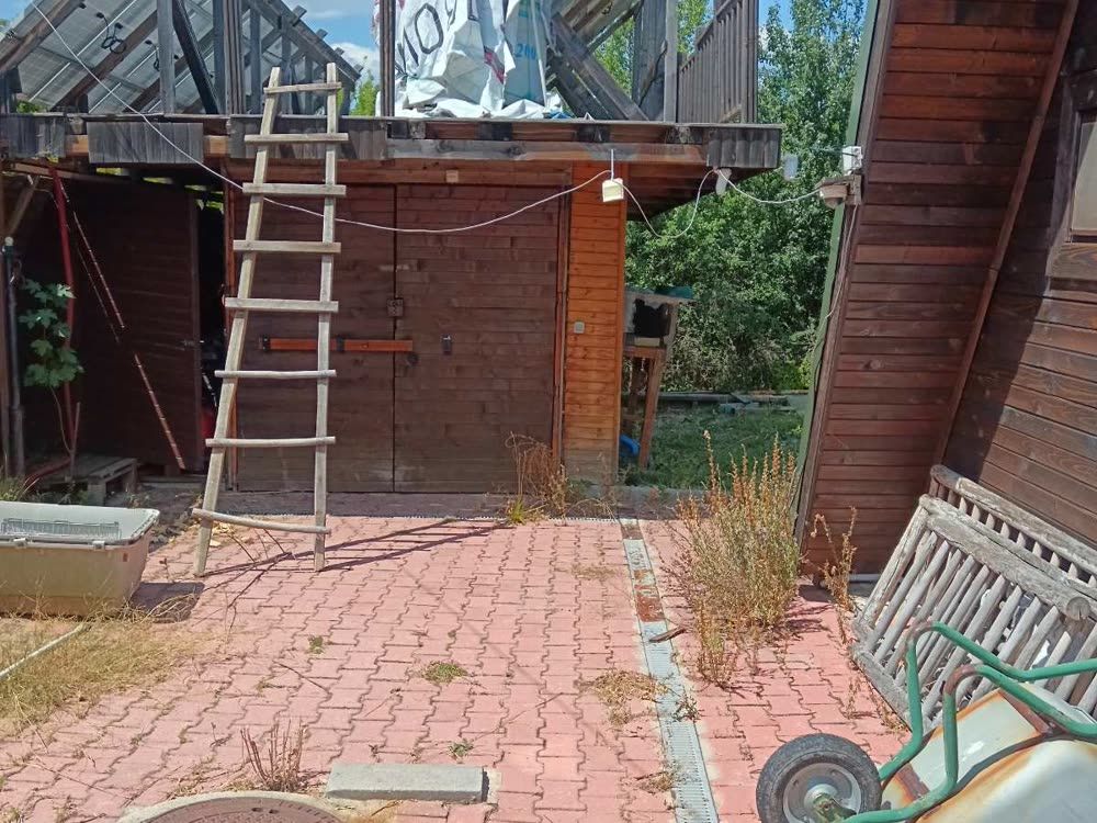 Вътрешен двор с плочки и плевели, разчистен от растителност