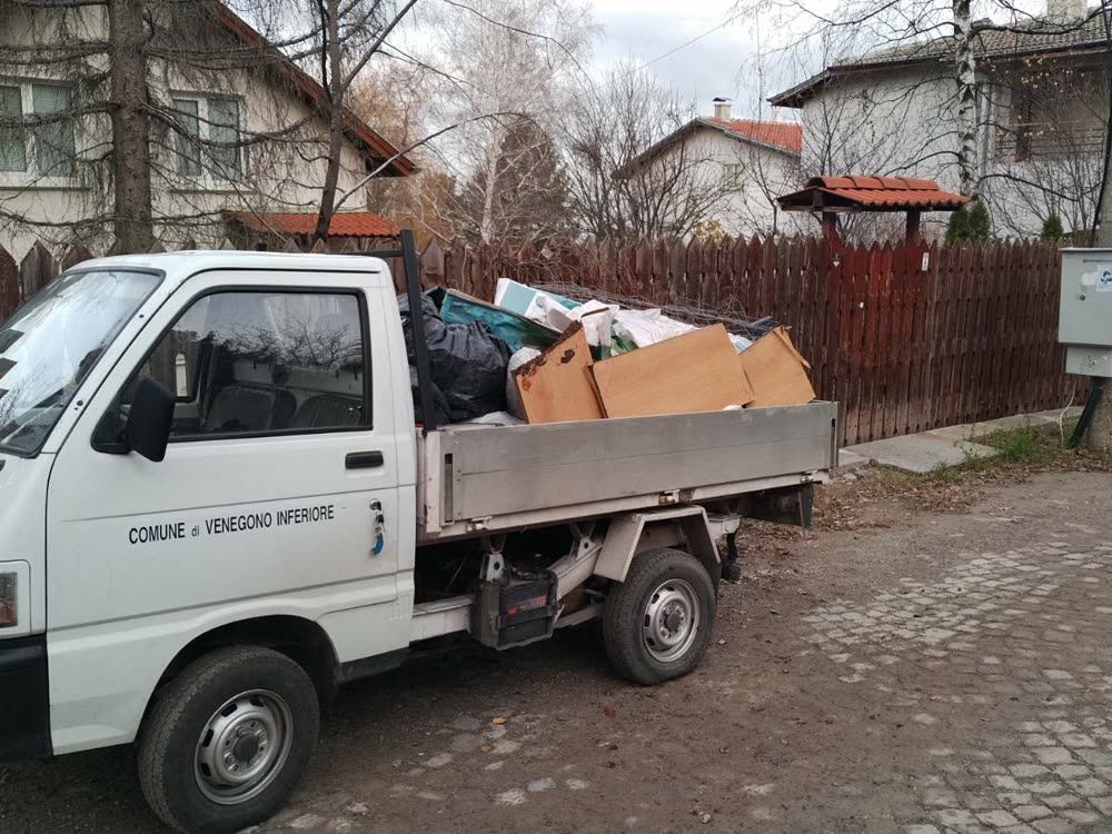 Самосвал с логото на фирмата, натоварен със строителни отпадъци, на улица